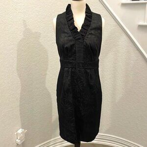Elegant black on black sleeveless embossed dress w/ ruffle detail & side zipper.